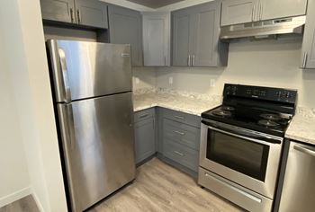 A kitchen with stainless steel appliances and marble counter tops